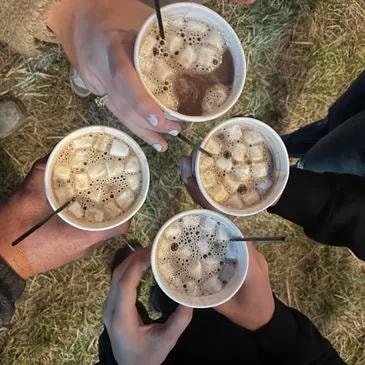 Friends holding drinks during an evening at the haunted trail